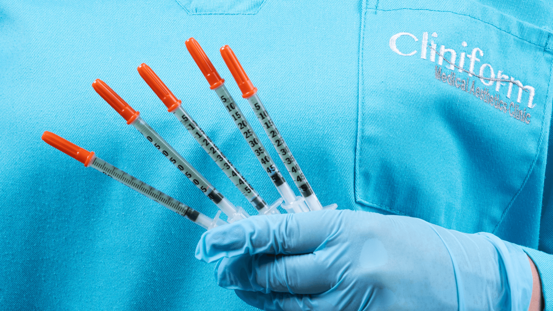 Cliniform practitioner holding prepared syringes